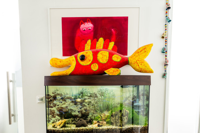 Nahaufnahme der Fischskulptur auf dem Aquarium vor einem roten Katzenbild
