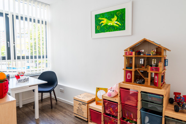 Wartezimmer mit Fenster, kleinem Maltisch, Puppenhaus und Spielzeugregalen